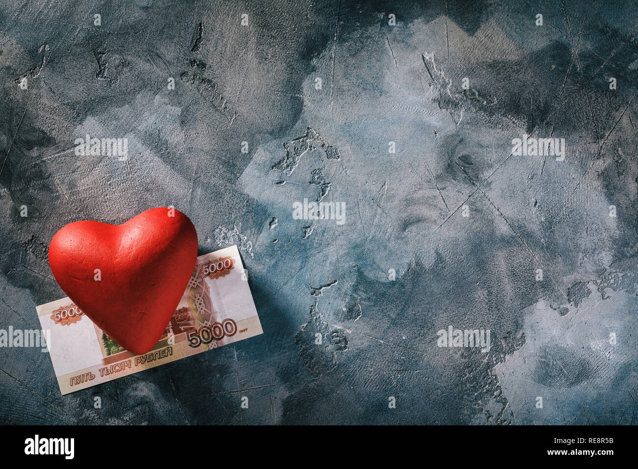 Die Liebe zum Geld. Rotes Herz und fünf Tausend Rubel auf die Tabelle mit Platz kopieren, Ansicht von oben in das Gesamtkonzept Stockfoto