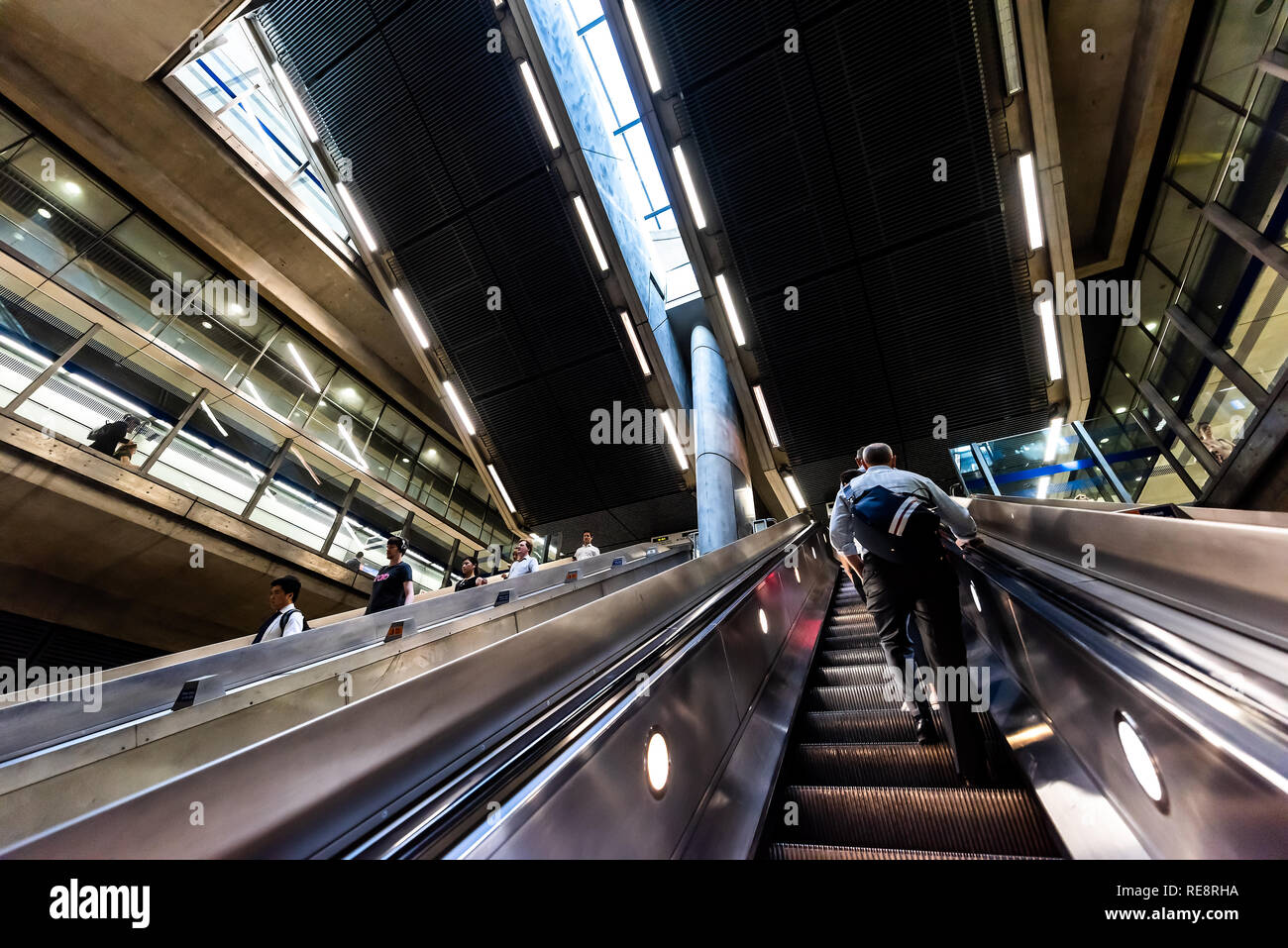 London, UK, 26. Juni 2018: Leute Pendler reiten Rolltreppen im U-U-Bahn während der morgendlichen Fahrt zum Arbeitsplatz in Canary Wharf mit Mode Stockfoto