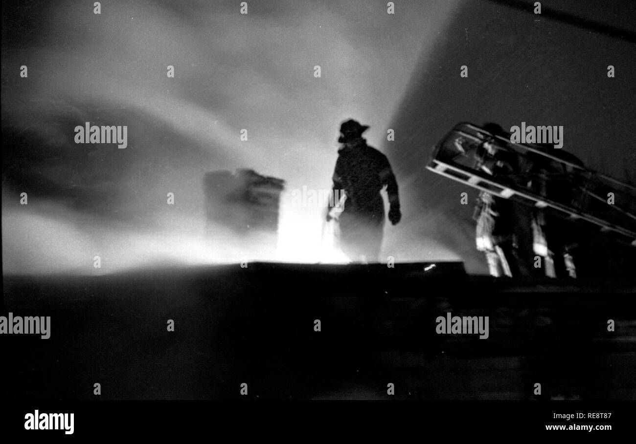 Boston Feuerwehr Feuerwehrmänner auf der Oberseite der Brand in Dorchester Ma USA Foto eines tenament Dach von Bill Belknap 1980 Stockfoto