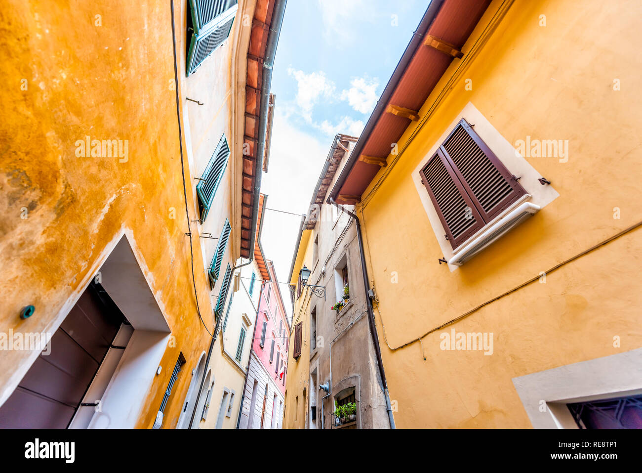 Chiusi, Italien Straße in kleinen mittelalterlichen Stadt Dorf in Umbrien suchen Low Angle View während der sonnigen Tag mit niemand orange gelb hell Vib Stockfoto