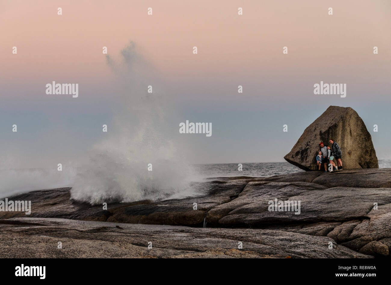 Bicheno-Blasloch. Familie nimmt Deckung von großer Welle von Bicheno Blowhole (Blowhole) Stockfoto
