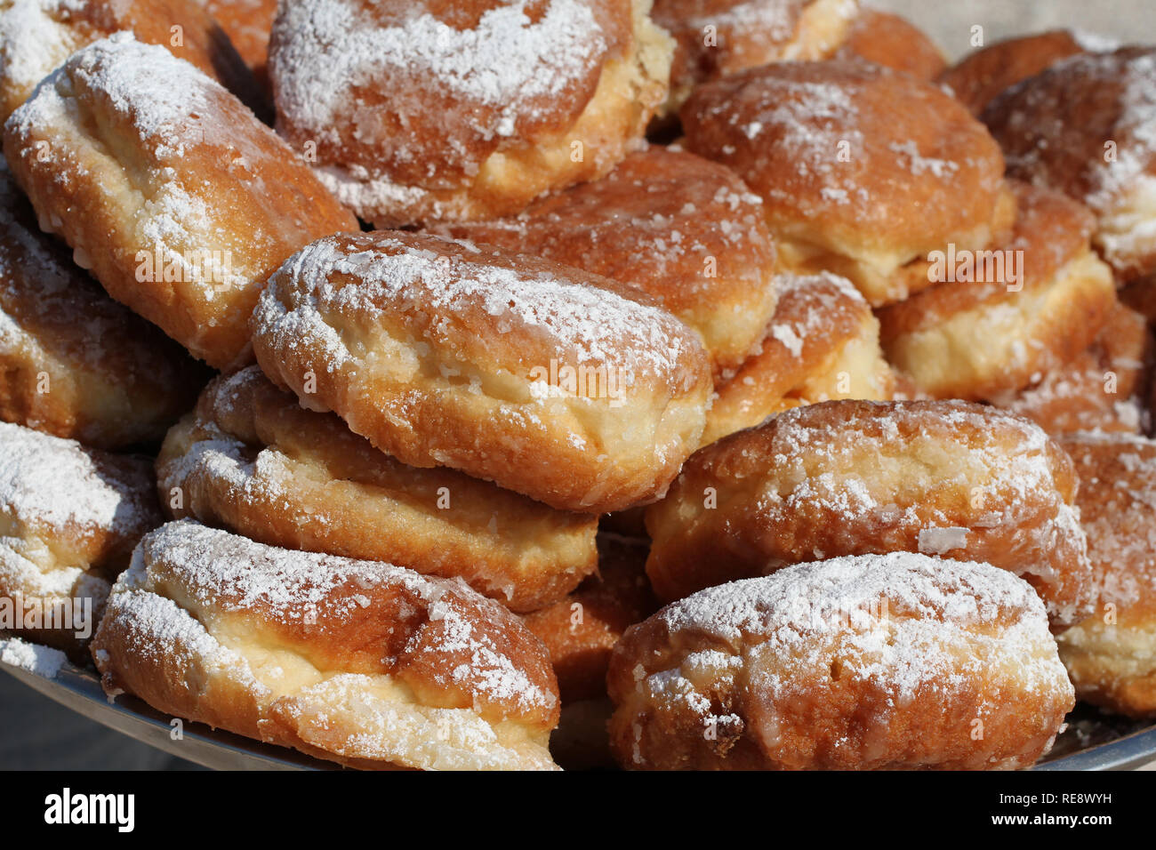 Gebratene Vanillepudding donuts bestreut mit Puderzucker, auf das Fach Closeup übereinander gestapelt Stockfoto