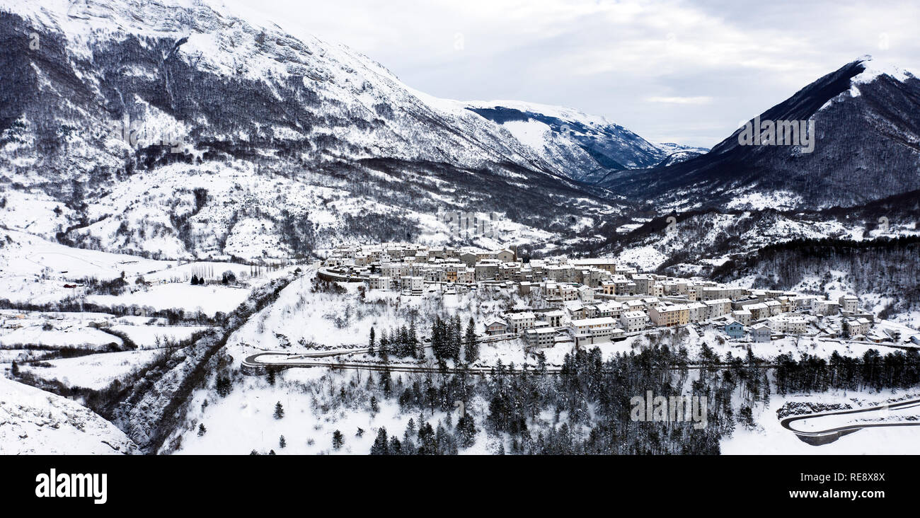 Luftaufnahme der Schönen verschneiten Dorf Opi mit schneebedeckten Bergen im Hintergrund. Stockfoto