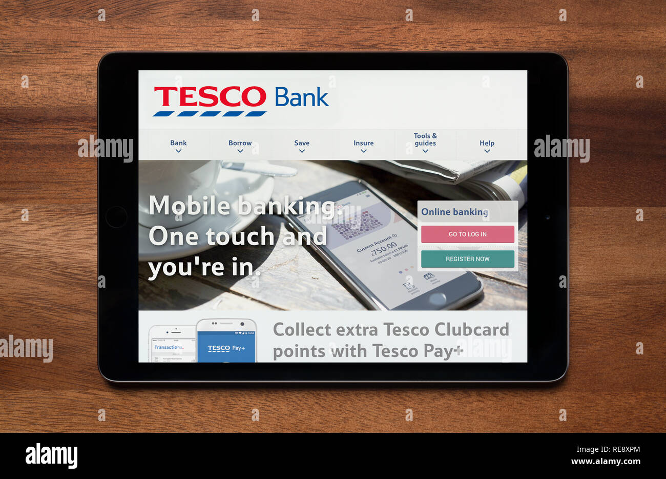 Die Website von Tesco Bank gesehen auf einem iPad Tablet, der ruht auf einem Holztisch (nur redaktionelle Nutzung). Stockfoto