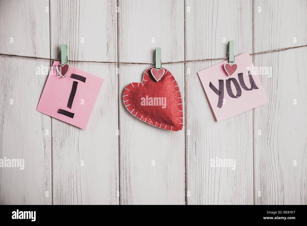 Valentines Tag Karte. Herz und Blatt Papier am Seil mit Worten der Liebe auf alten weißen Holz Hintergrund Stockfoto