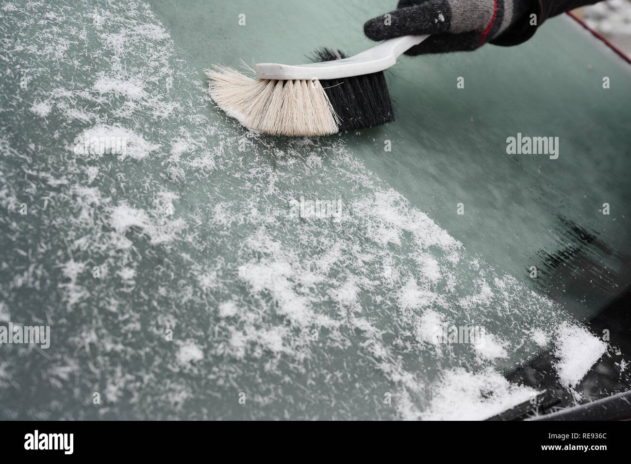 Hand Besen fegt den Schnee aus der Halterung für die Windschutzscheibe eines Autos im Winter, Kopieren, ausgewählte konzentrieren Stockfoto