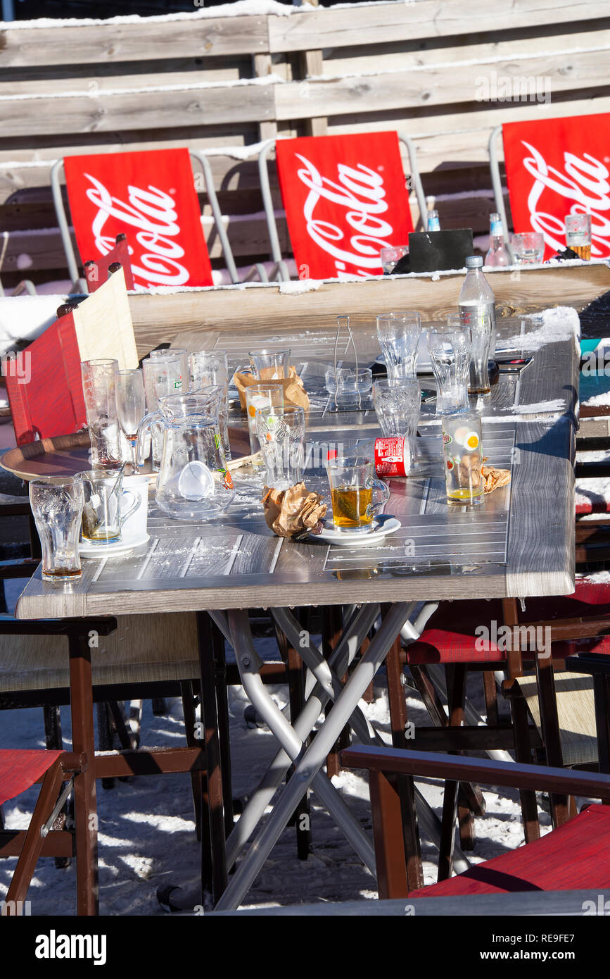 Leere Gläser und Müll nach links auf einen Tisch im Restaurant Le Sonnenstühle und Gondel in Morzine Skigebiet Portes du Soleil Haute Savoie Frankreich Stockfoto