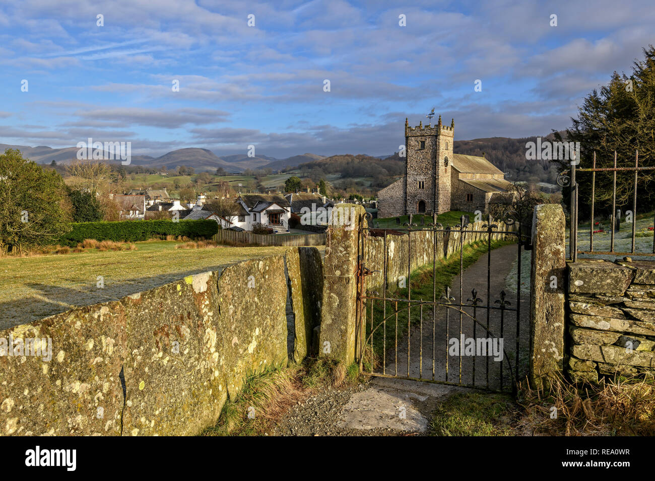 Die imposante Kirche St. Michael und alle Engel stehend über dem schönen Dorf Hawkshead mit Blick auf Latterbarrow und die fernen Fells Stockfoto