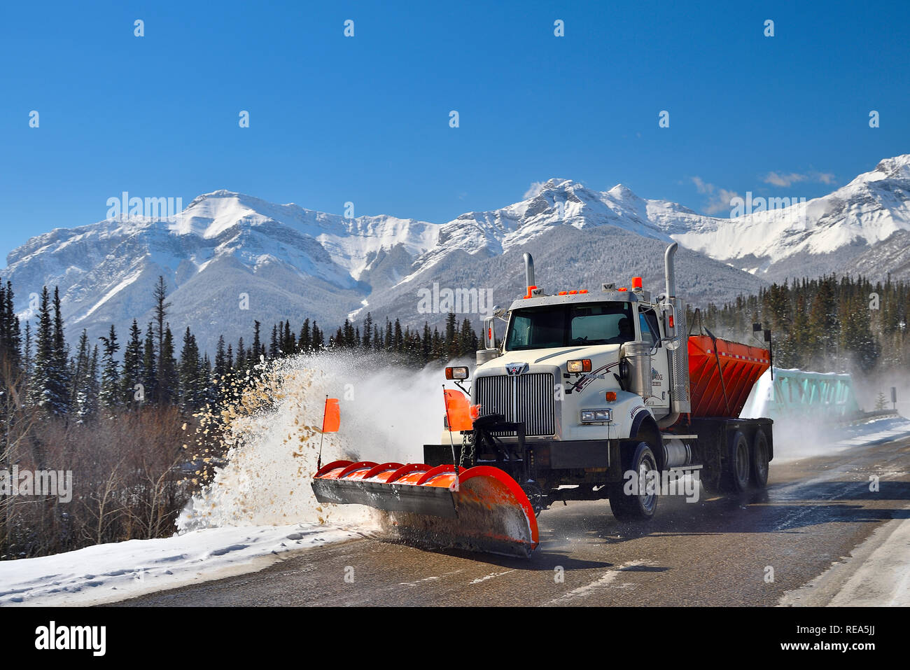 Ein LKW pflügt Schnee auf einer zweispurigen Autobahn in Die felsigen Berge in der Nähe von Brule Alberta Canada Stockfoto