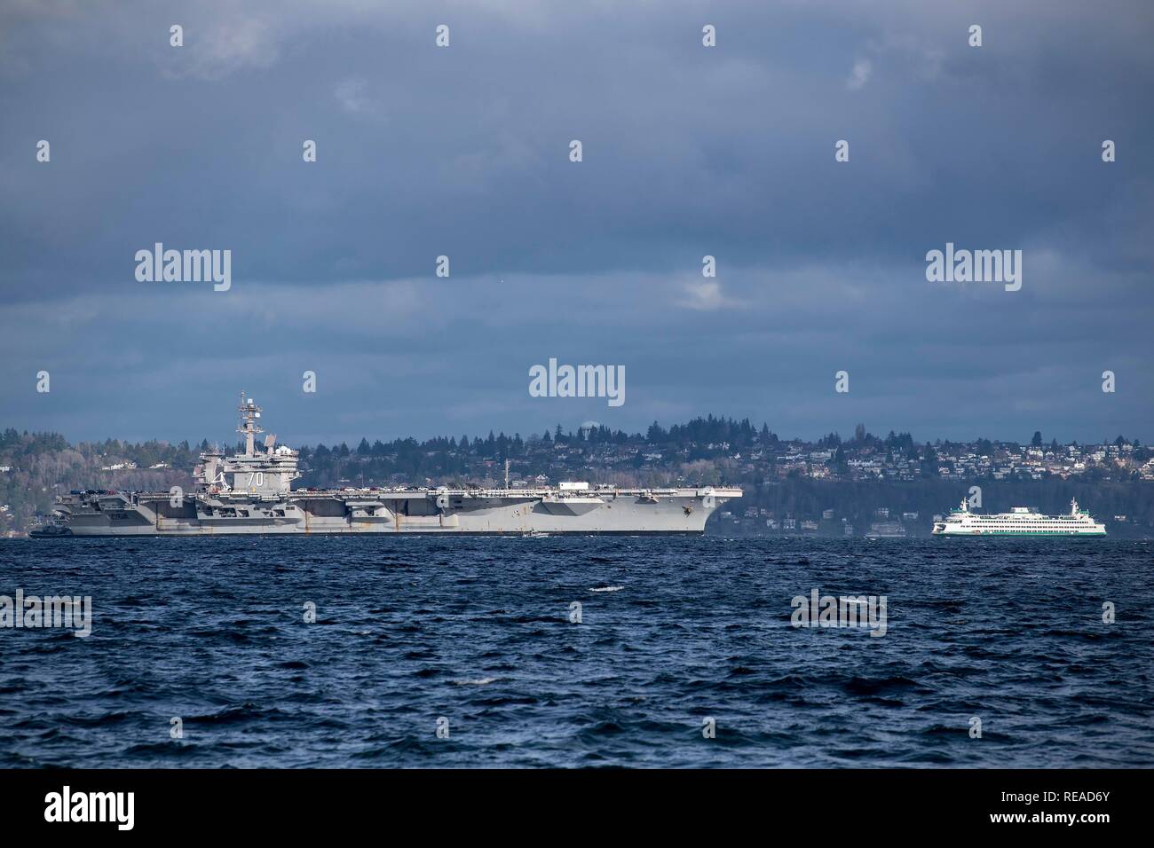 190120-N-EH 218-0028 PORT BLAKELY, Washington (Jan. 20, 2019) Der Nimitz-Klasse Flugzeugträger USS Carl Vinson (CVN 70) Segeln vorbei an einem Washington State Ferry, wie es den Puget Sound Transite auf dem Weg zum Marinestützpunkt Kitsap-Bremerton. Die Vinson geplant ist homeports nach Bremerton zu ändern, während der nimitz-Klasse Flugzeugträger USS John C Stennis (CVN 74) ihre Mitte durchläuft - Leben tanken Überholung in Newport News, Virginia (USA Marine Foto von Mass Communication Specialist 1. Klasse Ryan J. Batchelder/Freigegeben) Stockfoto