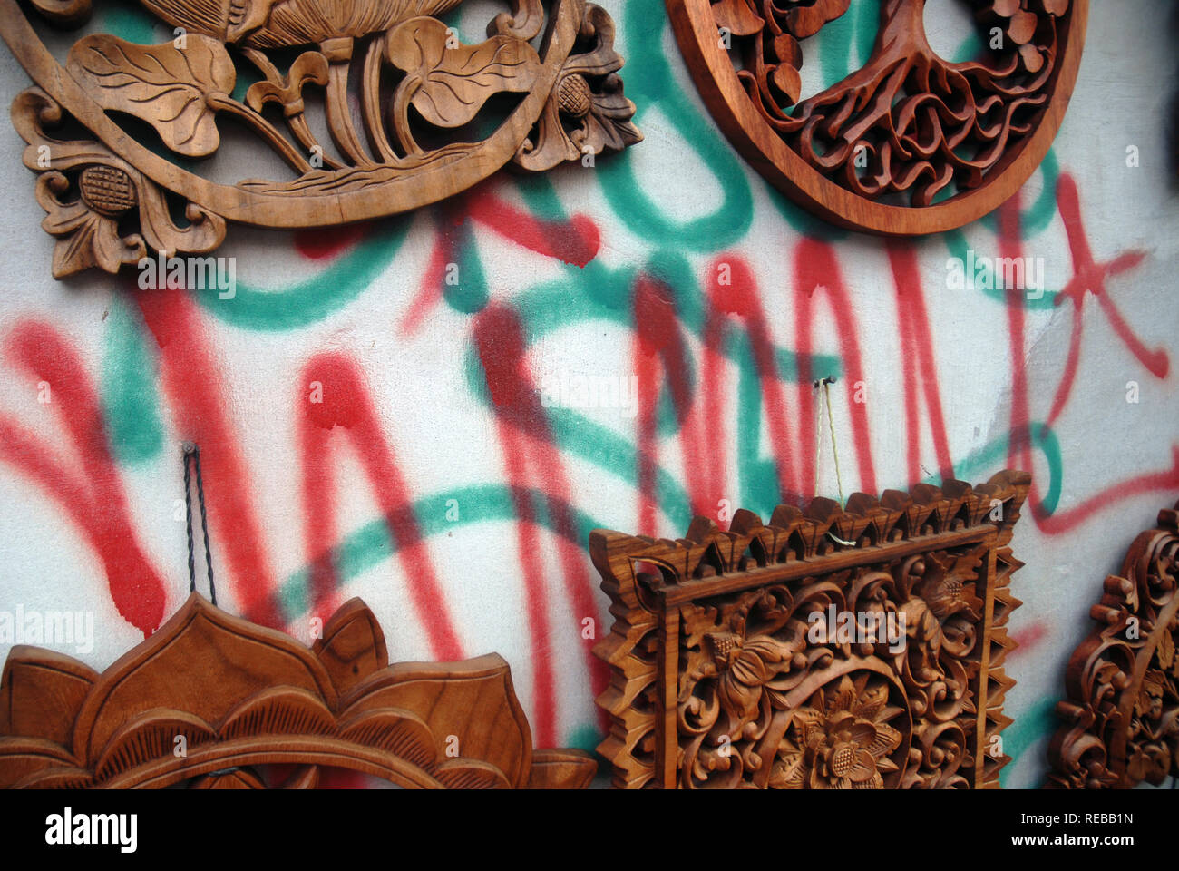 Graffiti gemalt auf Wand mit Holzschnitzereien, Ubud, Bali, Indonesien. Stockfoto