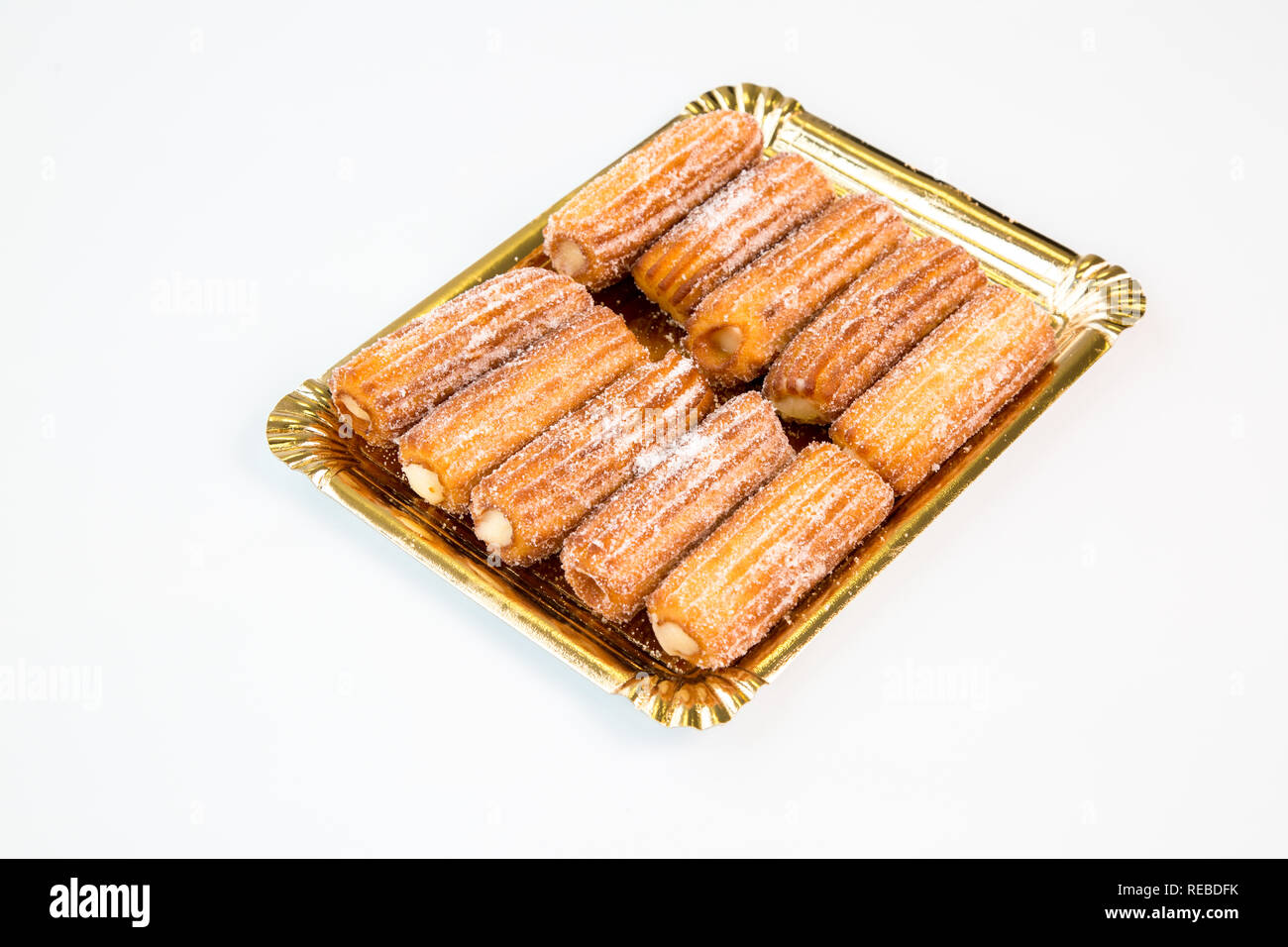 Süße Sahne verzetteln Churro auf einem goldenen Tablett mit weißem Hintergrund Stockfoto