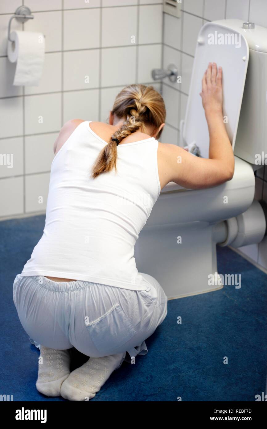 Frau Erbrechen in eine Toilettenschüssel, Übelkeit ist, Krankheit Stockfoto