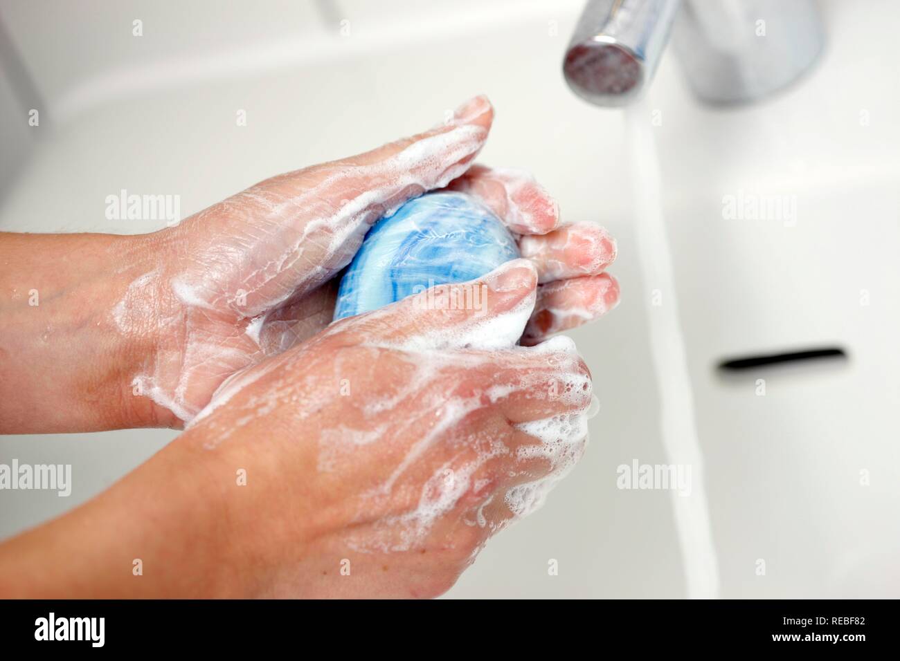 Die Hände werden in ein Waschbecken mit Wasser und Seife gewaschen Stockfoto