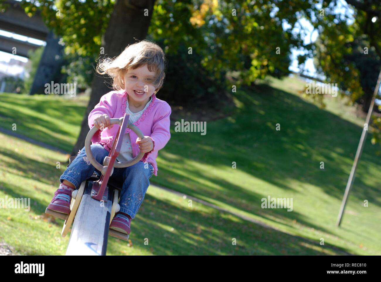 Zwei und ein halb Jahre alten Mädchen, die Spaß auf der Wippe in einem park Stockfoto