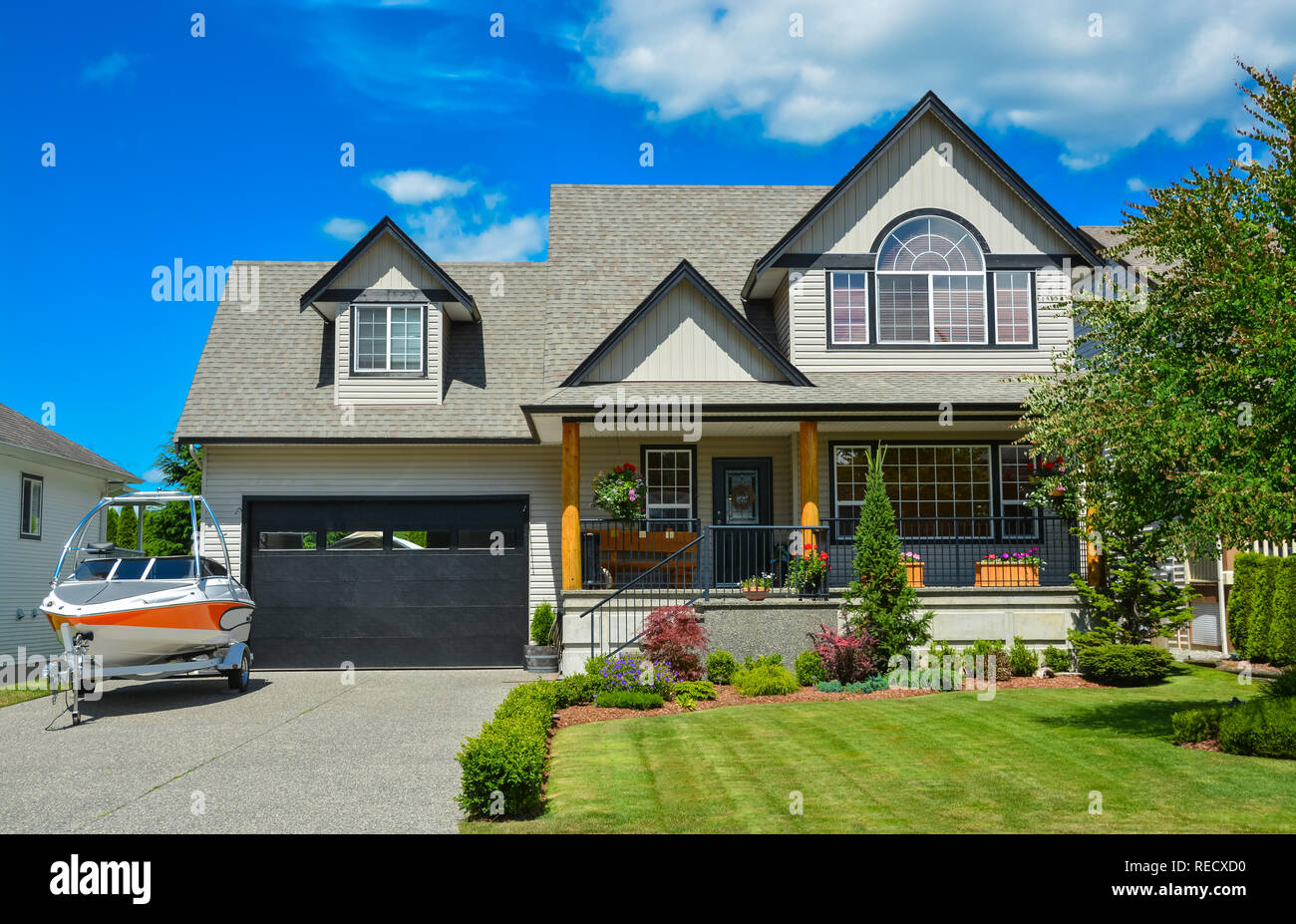 Suburban House mit Motorboot in der Einfahrt vor dem Haus geparkt Stockfoto