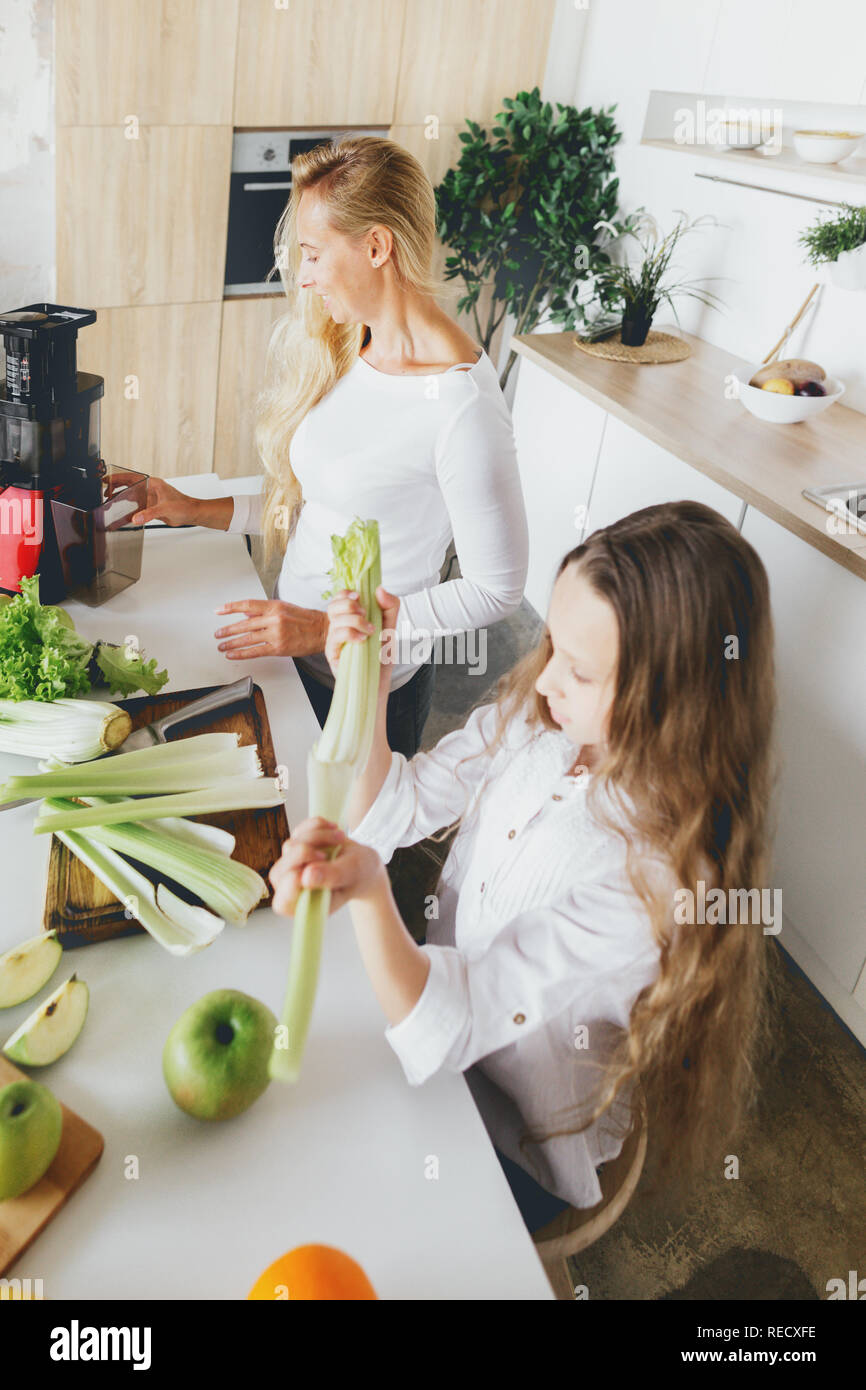 Glückliche Familie Kochen detox Cocktail zu Hause in der Küche. Glückliches Kind mit Mutter bereitet Frühstück Stockfoto