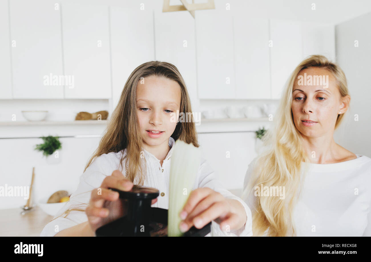 Glückliche Familie Kochen in der Küche. Glückliches Kind mit Mutter bereitet Frühstück Stockfoto