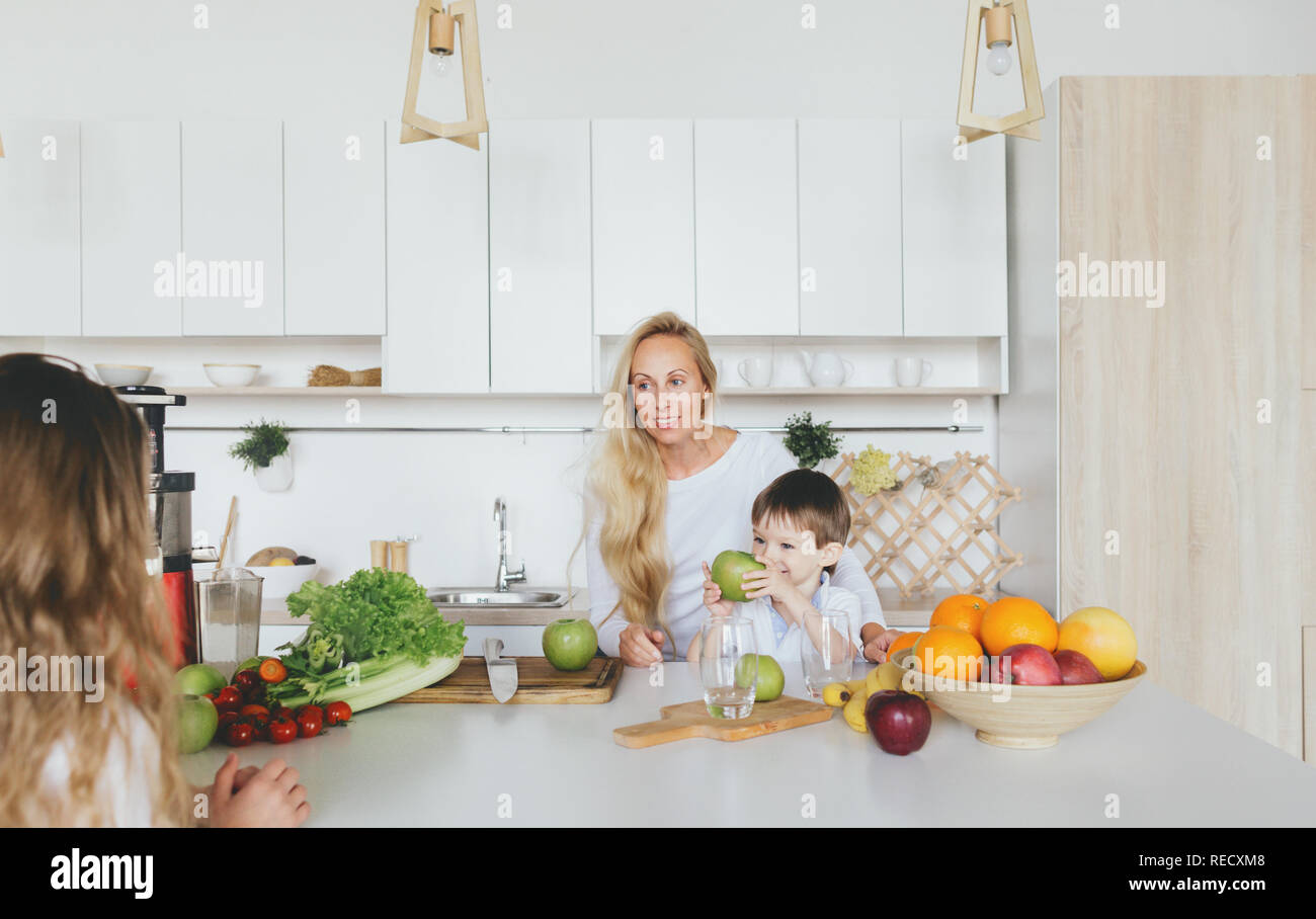 Happy Family Konzept. Glückliche Mutter mit ihren Kindern's Cooking Frühstück Home in der Küche Stockfoto