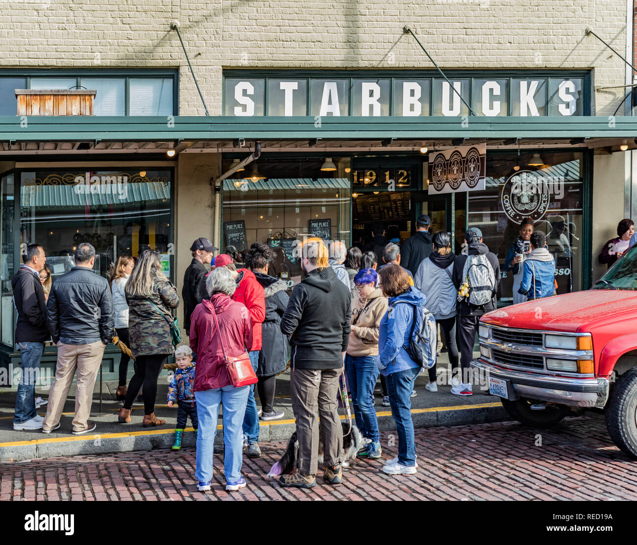 Seattle, Washington, USA - 28. Oktober 2018. Kunden in der Warteschlange auf dem Gehweg außerhalb des ursprünglichen Starbucks Coffee House um 1912 Pike Place. Stockfoto