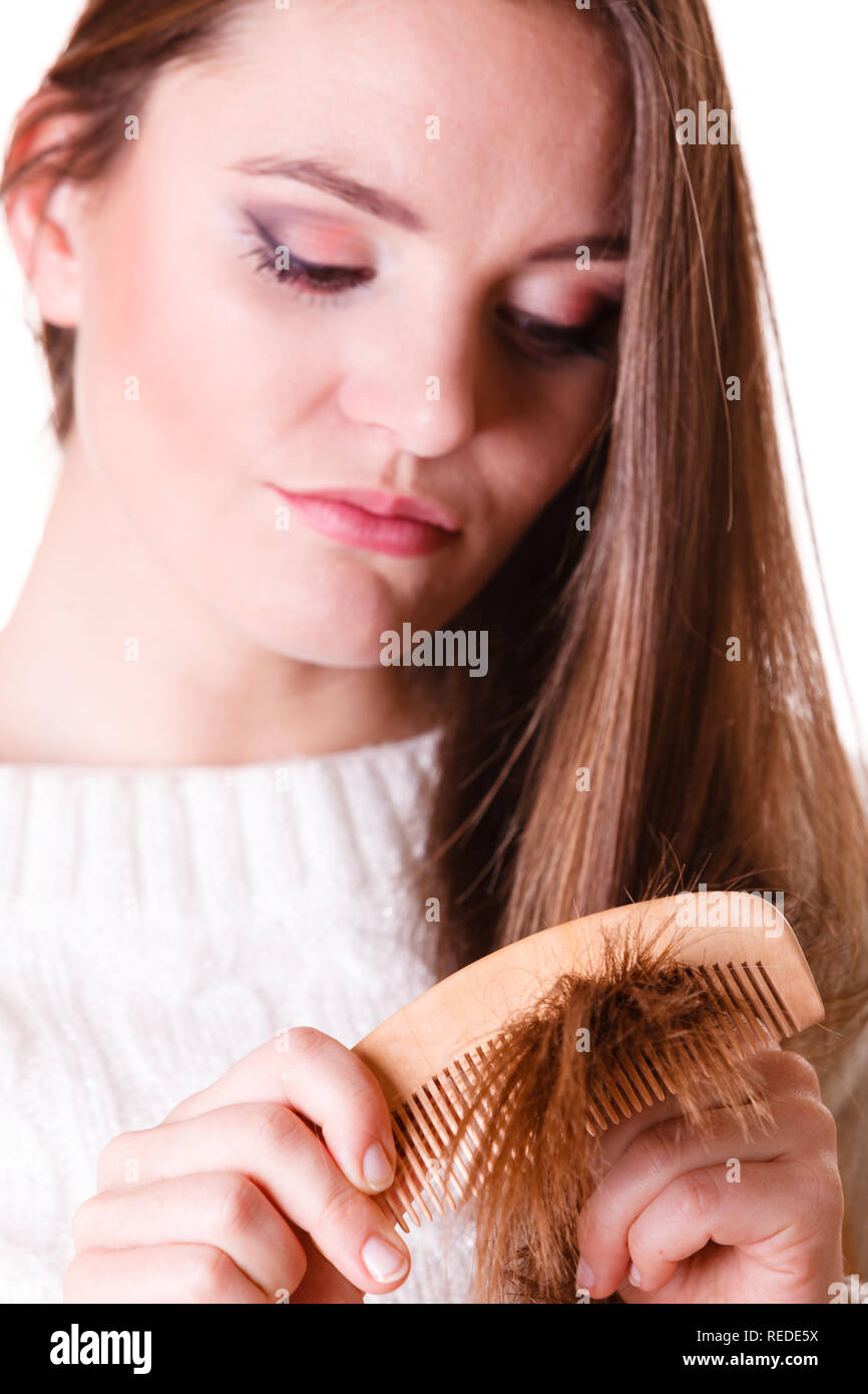 Unzufrieden Frau kämmen mit Pinsel und zieht an ihr langes Haar. Unglücklich für schönes Aussehen in der täglichen Aktivität. Stockfoto