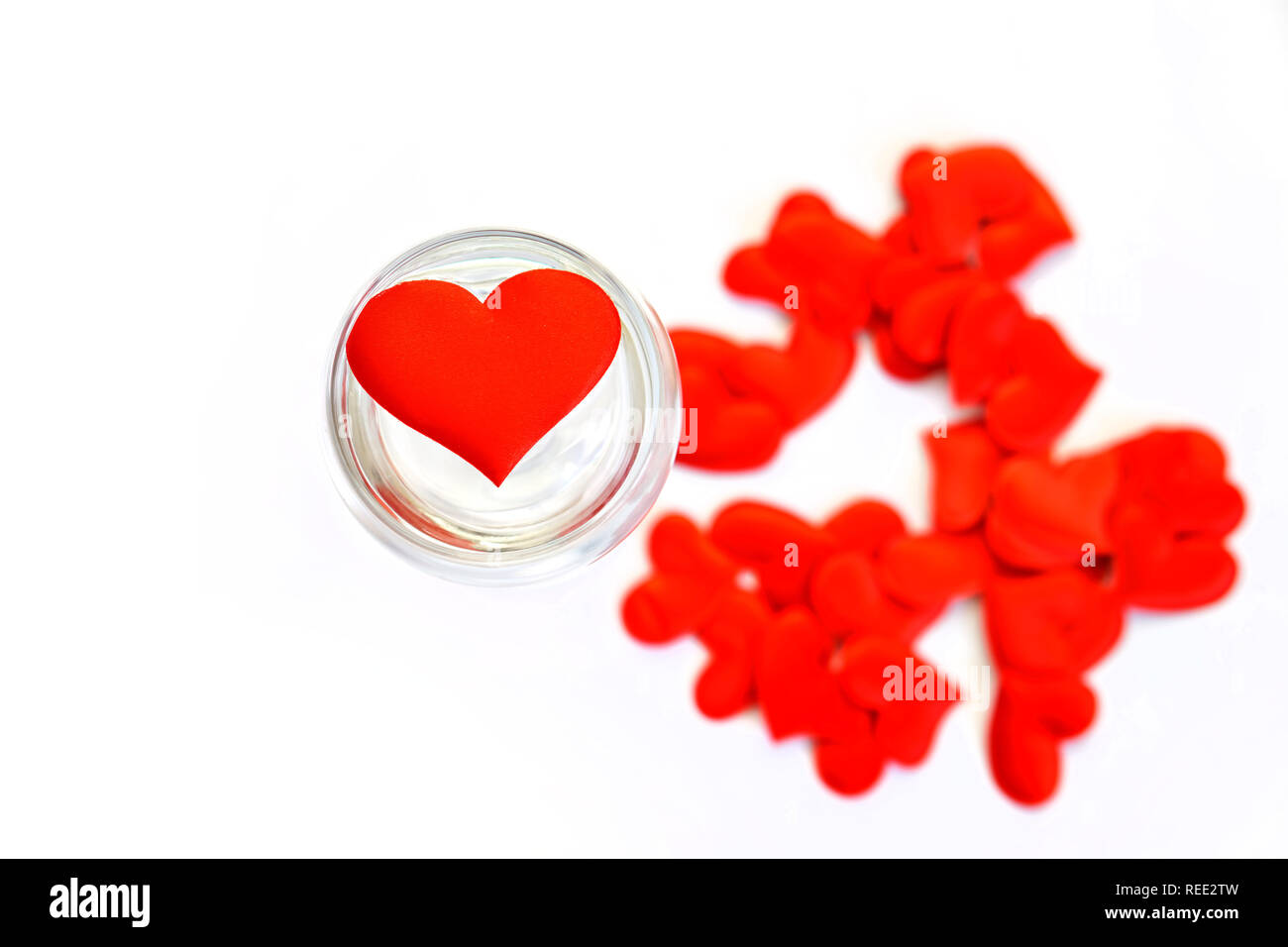 Rotes Herz in ein transparentes Glas auf einem weißen Hintergrund. Valentinstag. Herzlichen Glückwunsch zum Valentinstag. Stockfoto