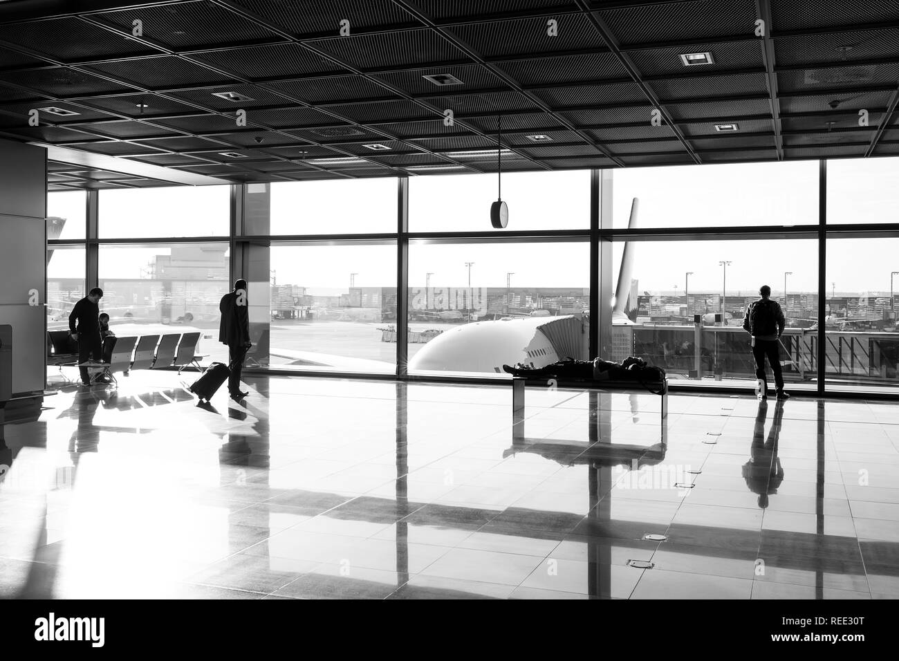 Frankfurt am Main, Deutschland - 11. Oktober 2015: touristische Passagiere mit Koffer, Gepäck in der Lounge Halle. Die Menschen warten für Flug im Flughafen am grossen Fenster Glas. Fernweh, Urlaub, Reise. Stockfoto