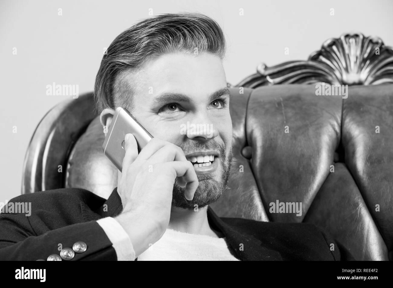 Mann oder Geschäftsmann, lächeln und sprechen Sie auf dem Smartphone auf Sofa. Business Communication Konzept. Unternehmertum, neue Technik, modernes Leben. Stockfoto