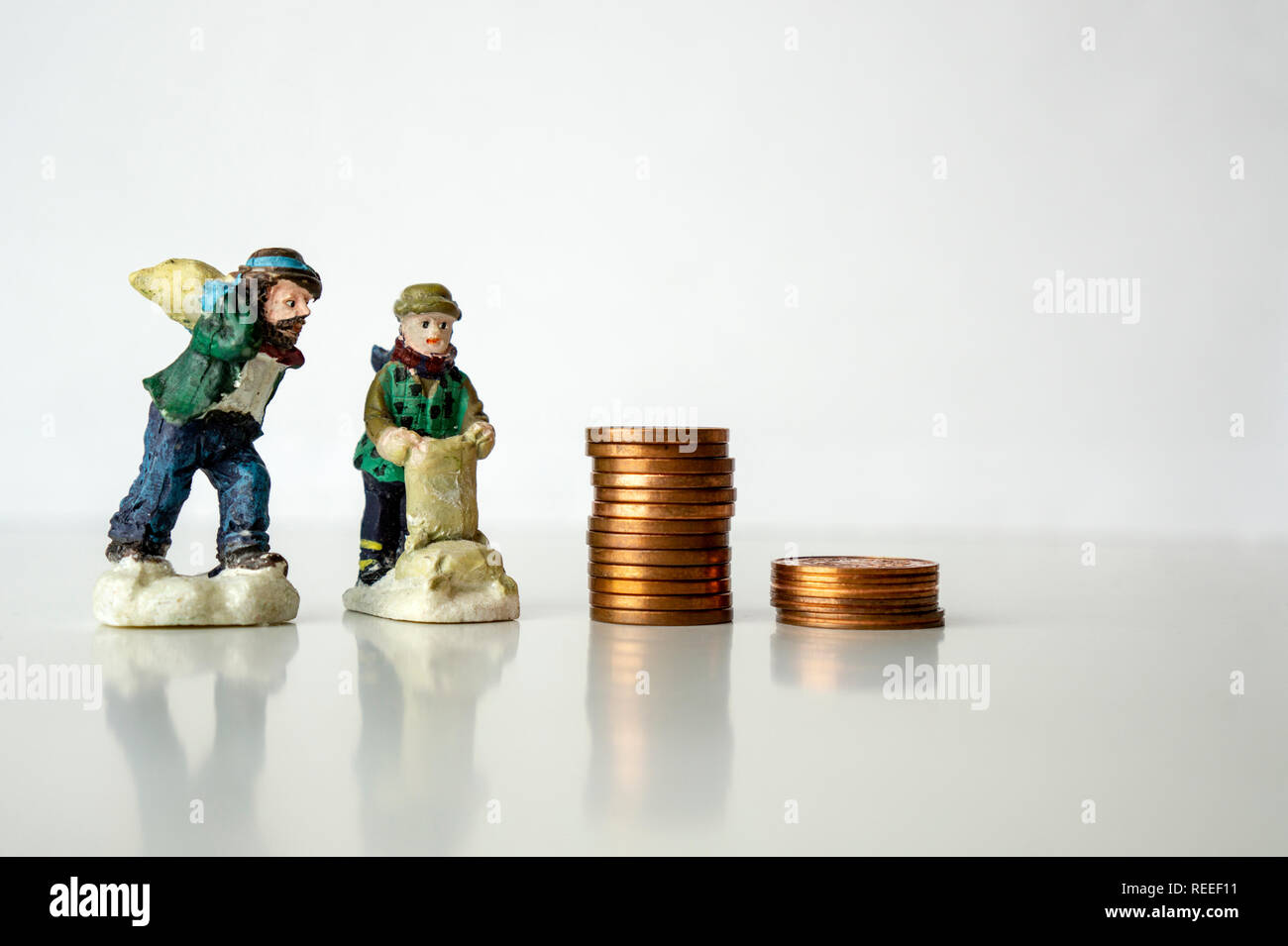 Stapel von Münzen mit Arbeiter zahlen auf weißem Hintergrund Arbeiten für ein paar Cent cent Konzept niedriges Gehalt Stockfoto