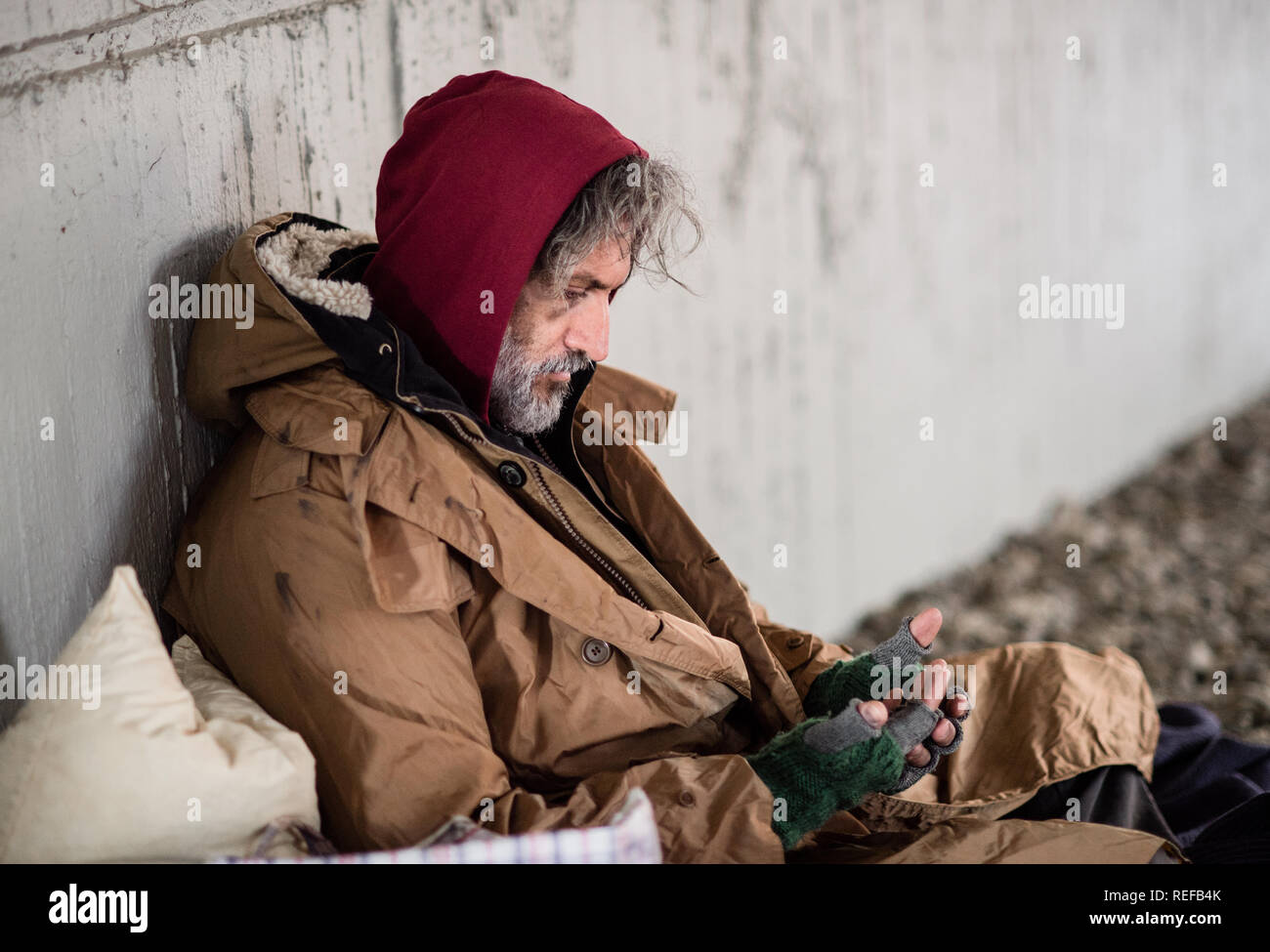 Obdachlose Bettler sitzen draußen in der Stadt bitten um Geld Spende. Stockfoto