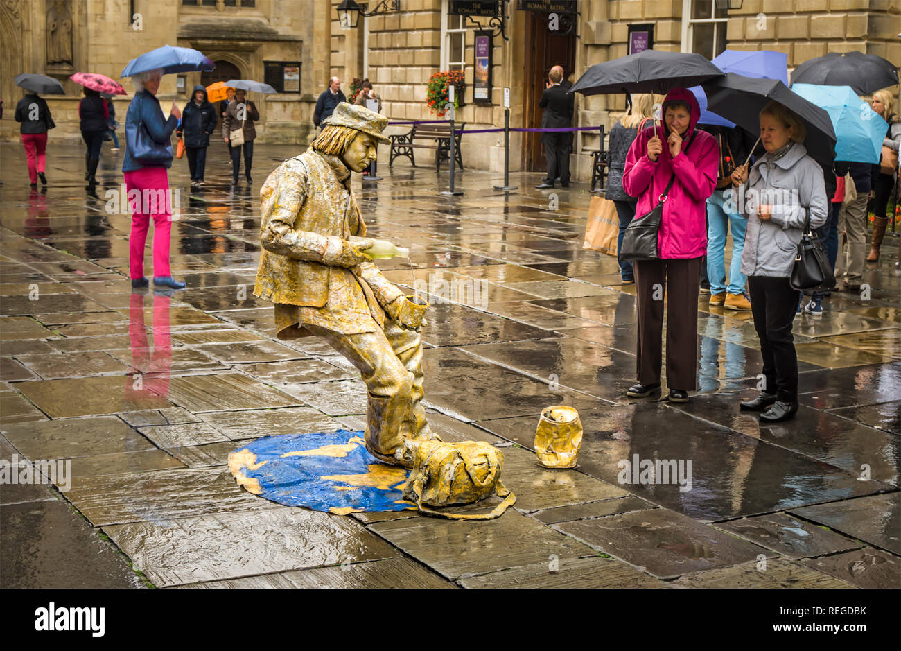 Street Performer zieht die Neugier der Massen an einem regnerischen Tag in Badewanne in Großbritannien Stockfoto