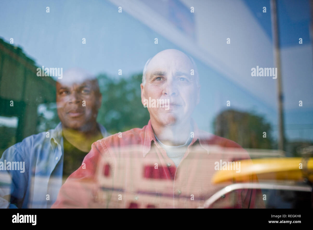 Zwei Männer, die durch ein Fenster aus Glas. Stockfoto