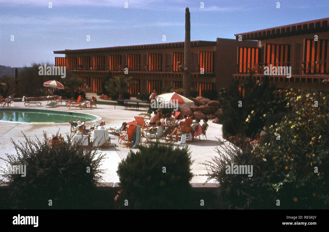 Szene rund um den Außenpool in einer modernen Wüste - style Hotel in Phoenix, Arizona, Juli, 1968. Die Gäste sich sonnen auf den konkreten Deck unter die Balkone der Gästezimmer. () Stockfoto