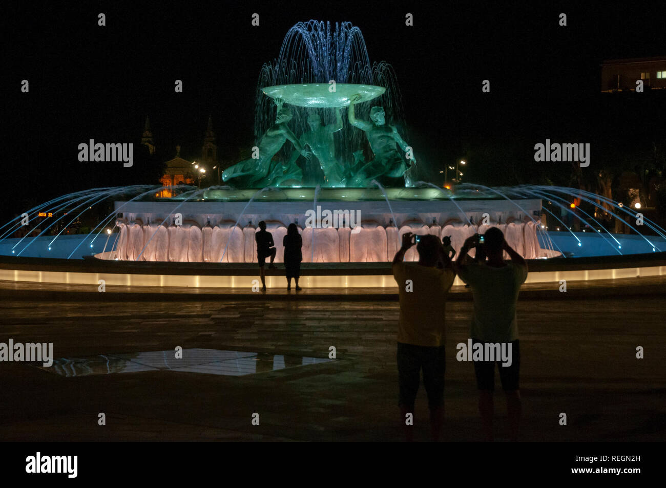 Besucher Fotos der restaurierten Triton Brunnen bei Nacht in der Nähe der Stadttore von Valletta, Malta. Stockfoto