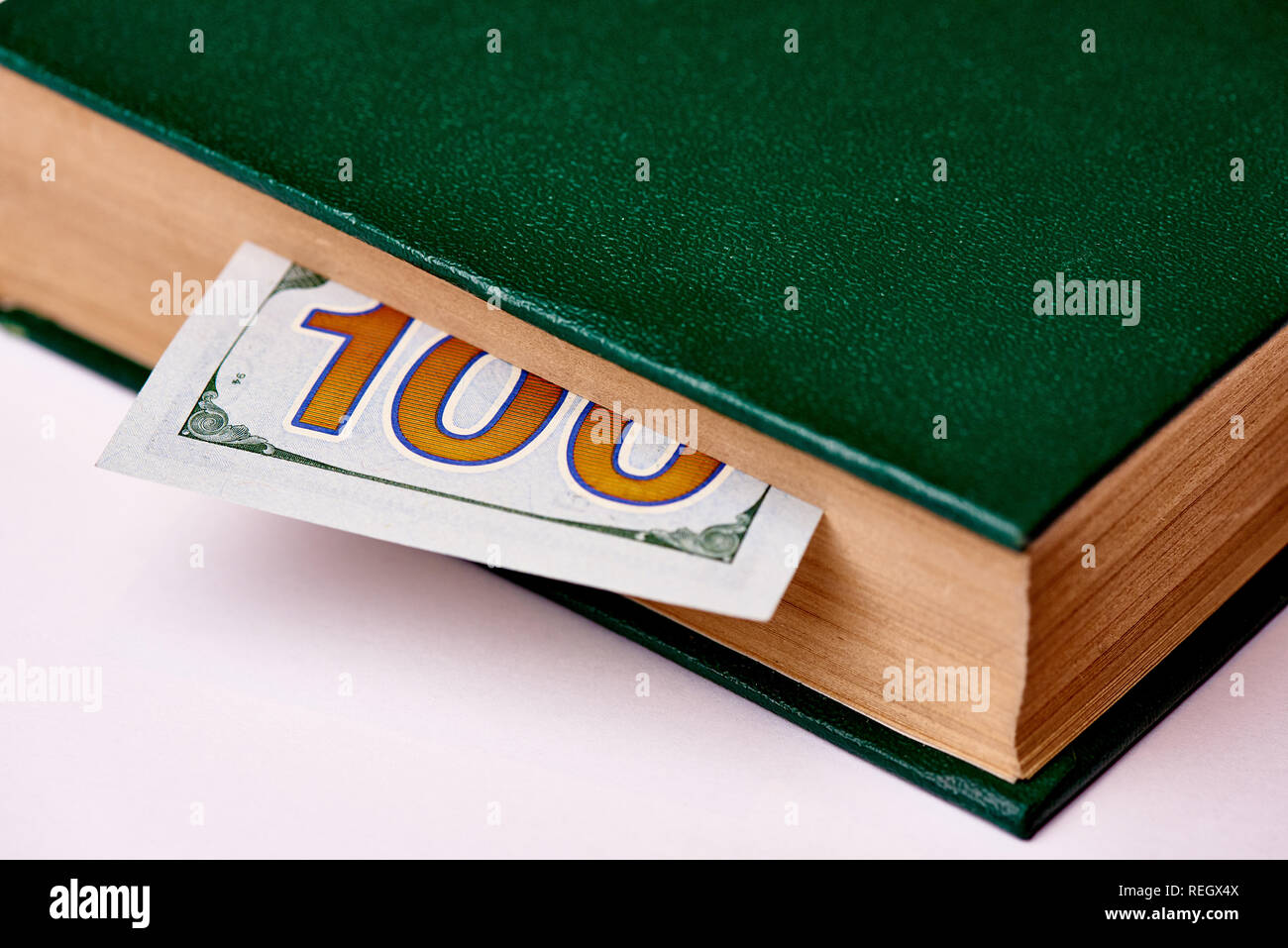 Bill im Wert von 100 US-Dollar im Buch auf einem weißen Hintergrund Makro. Stockfoto