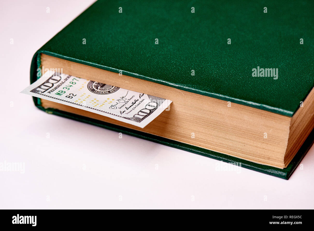 Bill im Wert von 100 US-Dollar im Buch auf einem weißen Hintergrund Makro. Stockfoto