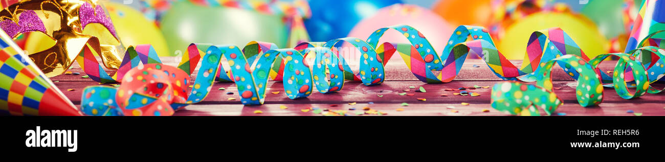 Bunte party, Karneval oder holiday Banner mit bunten twirled Bänder oder Streamer, Ballons und Konfetti in einem breiten Panorama Stockfoto