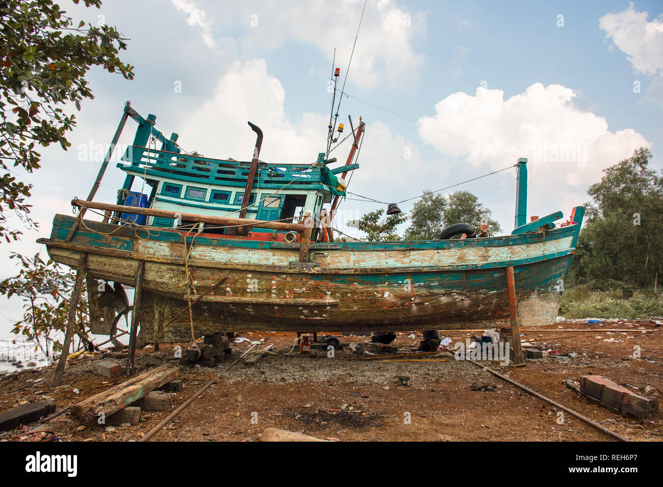 Eine verwesende alten kambodschanischen Holz Fischerboot auf unterstützt im Trockendock zu restaurieren. Stockfoto