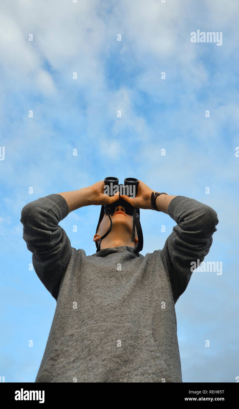 Teenager Jungen/jungen Mann suchen der Stationen durch ein Fernglas Stockfoto