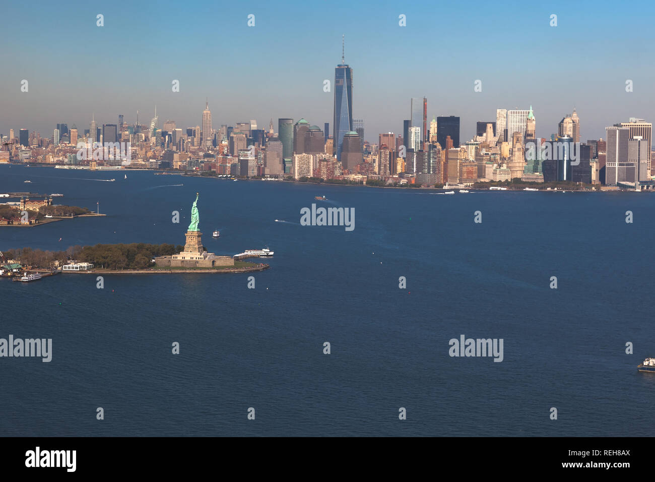 Helikopterblick auf Freiheitsstatue auf Hintergrund downtown Manhattan. Luftaufnahme. Liberty IslandManhattan, New York City, New York. Stockfoto