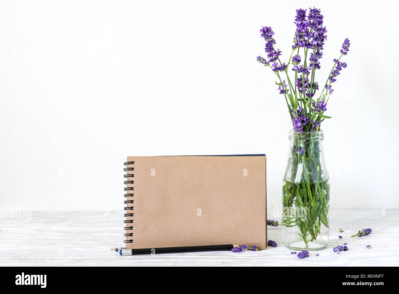Kreative mock up mit einem schönen Blumenstrauß aus Lavendelblüten und Leere hipster Notebook mit Platz für Text. Urlaub oder Hochzeit Hintergrund. Noch lif Stockfoto