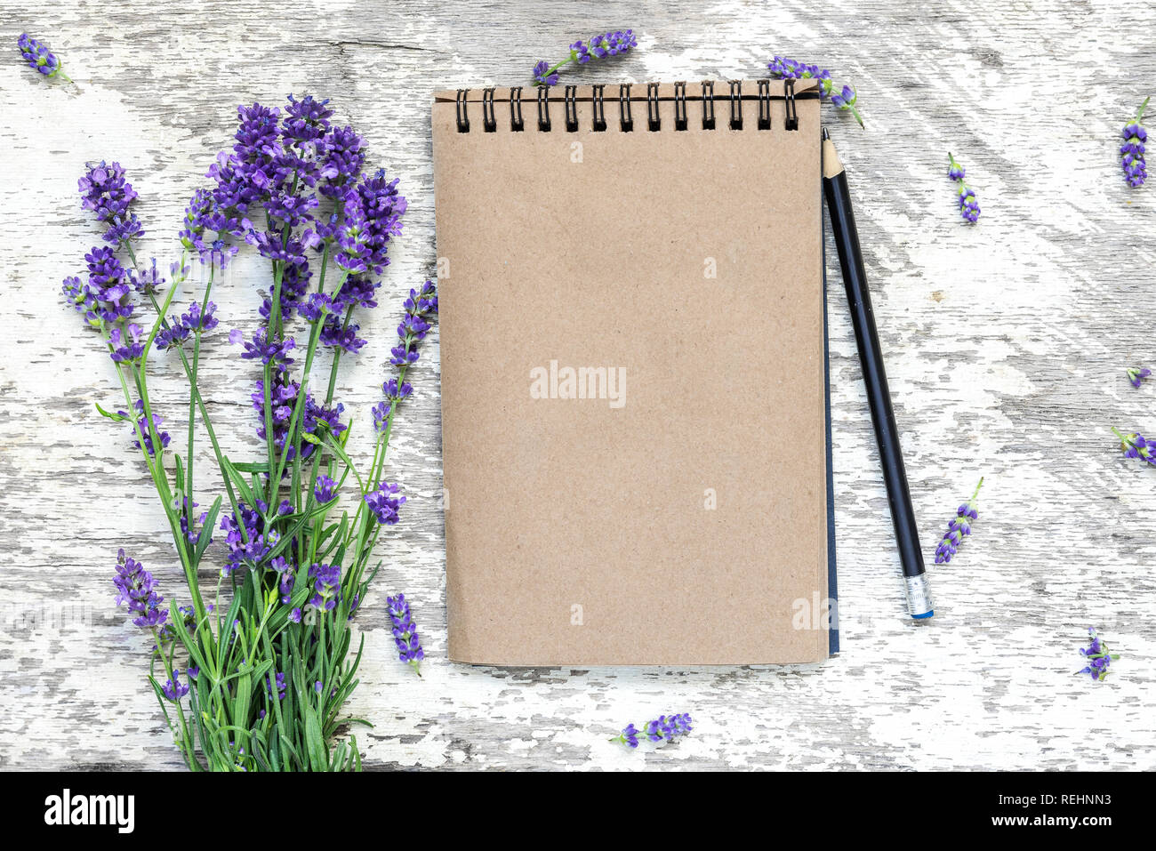 Leere vintage Notepad mit Lavendel Blumen Blumenstrauß und Bleistift über weiße Holztisch. top anzeigen. Mock up. Flach Stockfoto