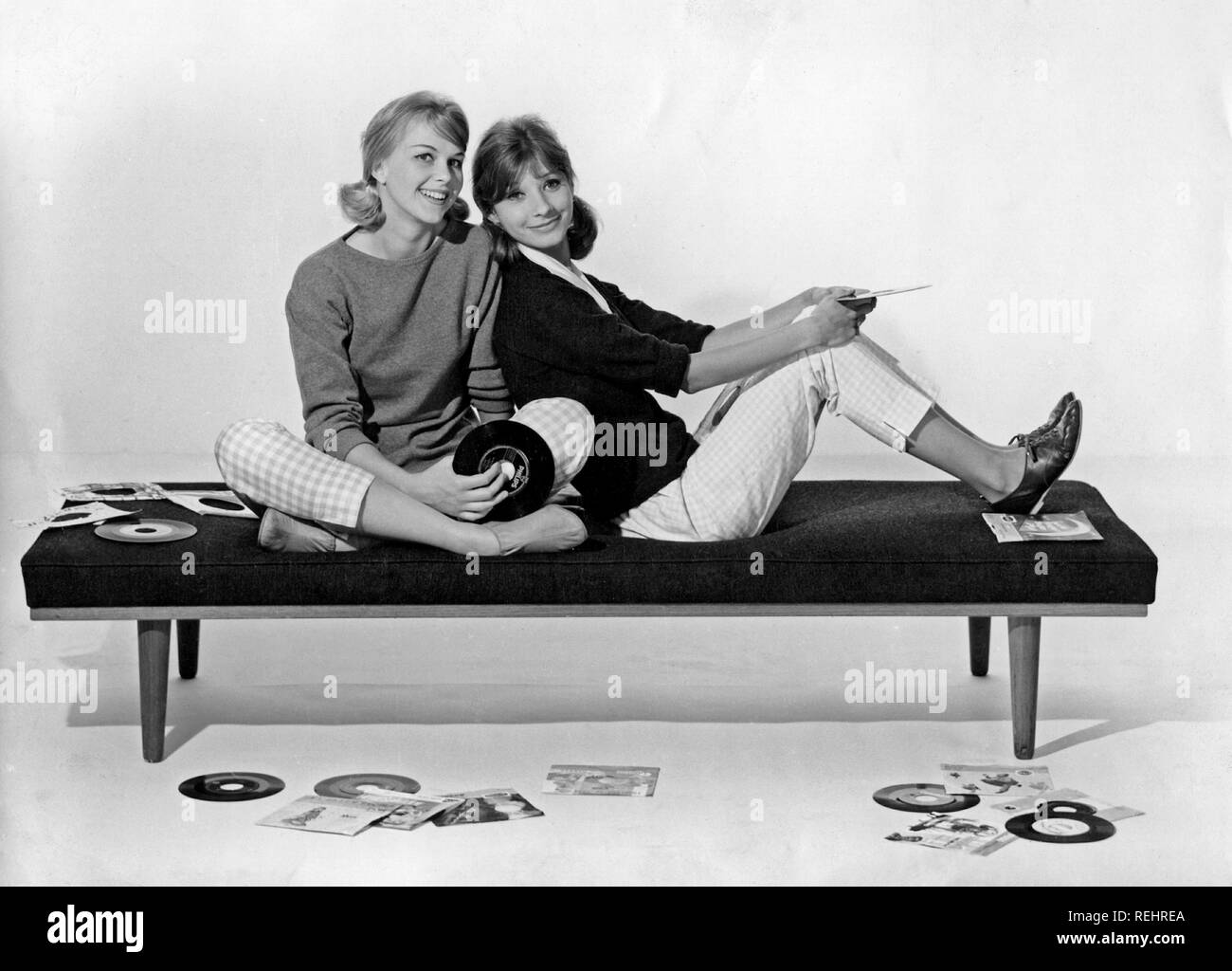 1960er jahre lifestyle. Zwei Mädchen in typischen 60er Jahre Kleider sitzen Holding Music Records. Schweden 1960 Stockfoto