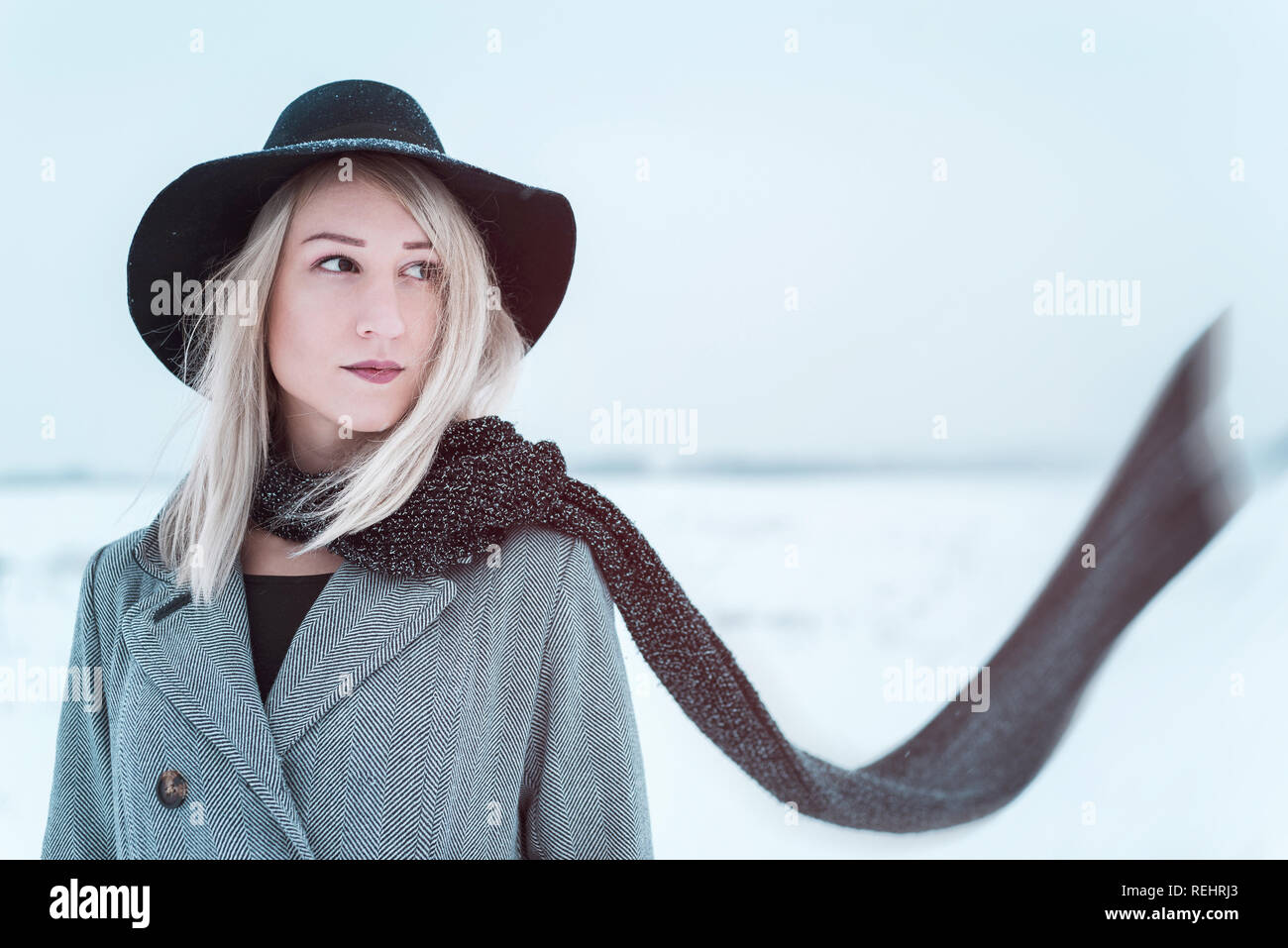 Junge Frau mit Kopftuch in der windigen im Winter Feld Stockfoto
