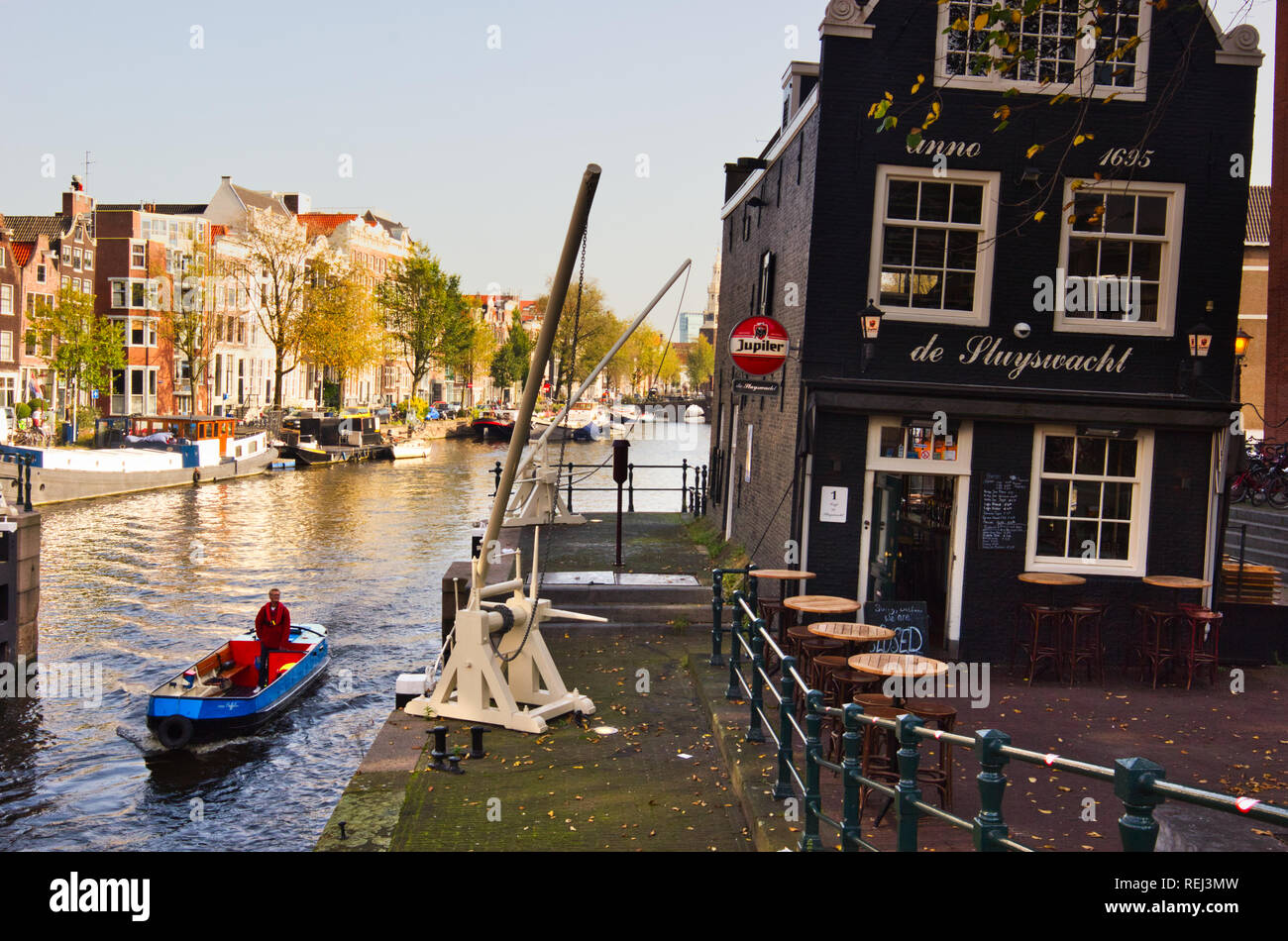 Boot durch Sint Antoniesluis Schleuse und das Krumme Cafe De Sluyswacht ein ehemaliger lock keepers House, Amsterdam, Niederlande, Europa, Stockfoto