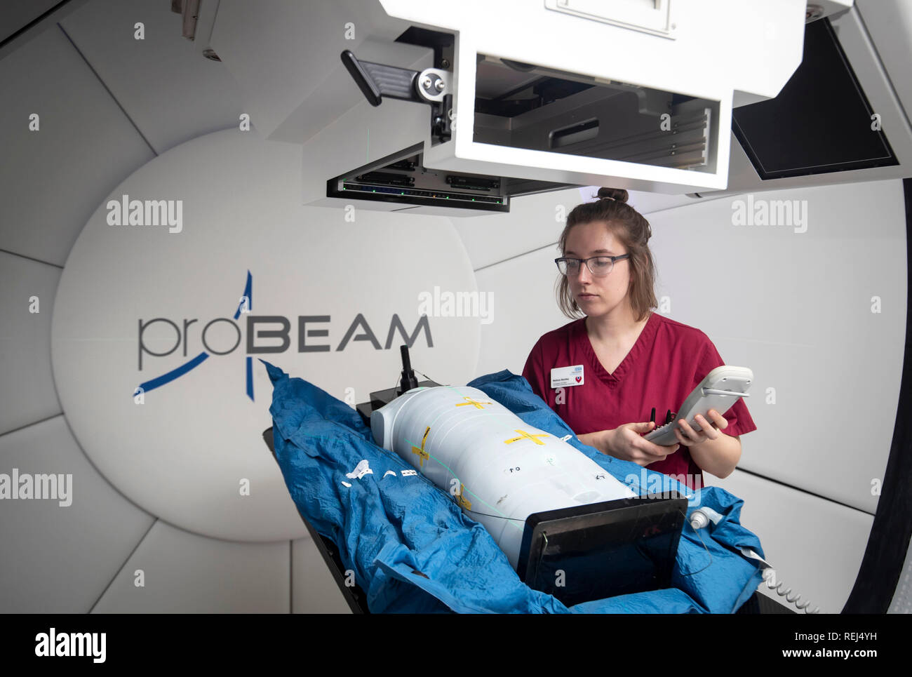 Mittwoch, 23. Januar 0001: Die Radiographin Melissa Bentley zeigt mit einem Testdummy das neue Proton Beam-Therapiezentrum des NHS im Krankenhaus Christie in Manchester, als die 15-jährige Mason Kettley (nicht abgebildet), die einen seltenen Hirntumor hat, sich auf die weltweit führende Behandlung vorbereitet. Stockfoto