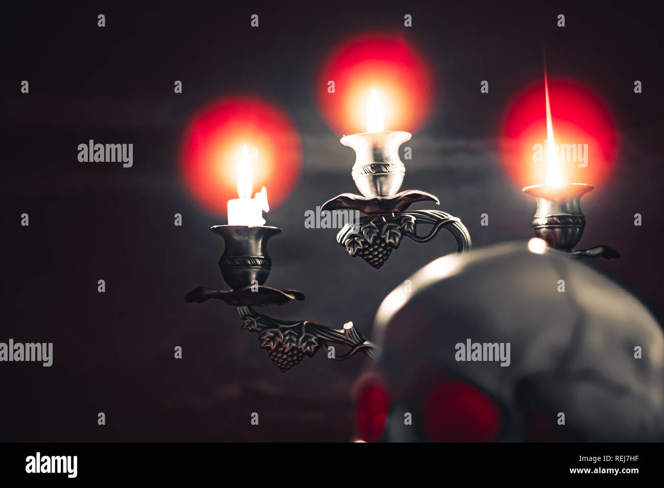 Kerze anzünden von Schädel mit Kerze und Bücher auf dem Schreibtisch aus Holz dekorieren für Halloween Theme mit kopieren. Noch immer leben Bild und selektiven Fokus Stockfoto