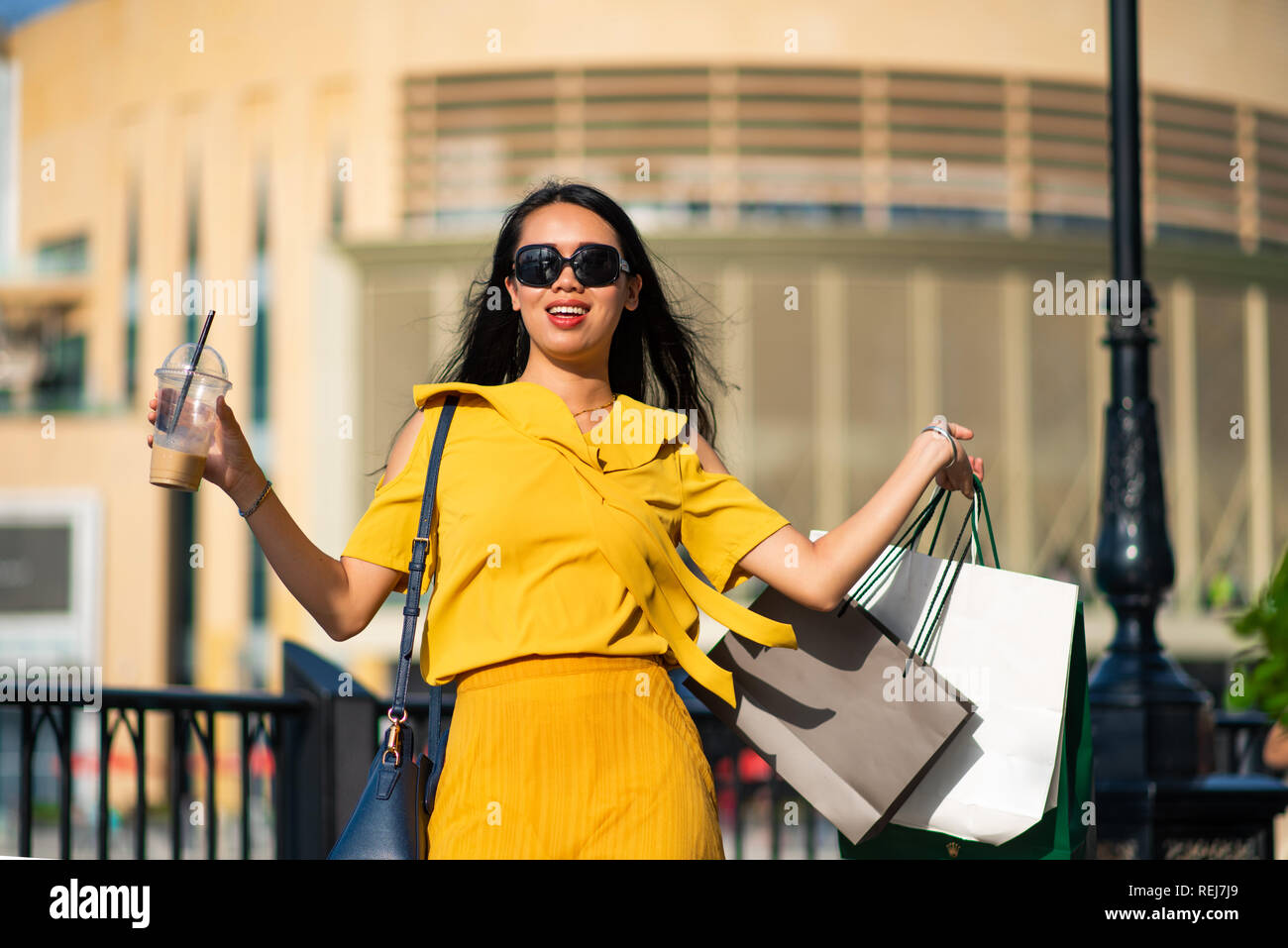 Gerne asiatische Mädchen mit Einkaufstaschen im Freien Stockfoto