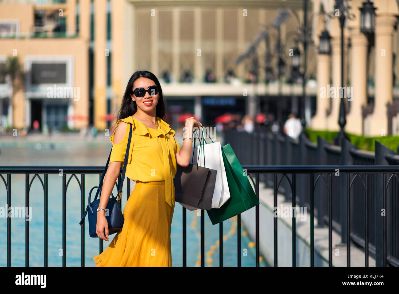Gerne asiatische Mädchen mit Einkaufstaschen im Freien Stockfoto