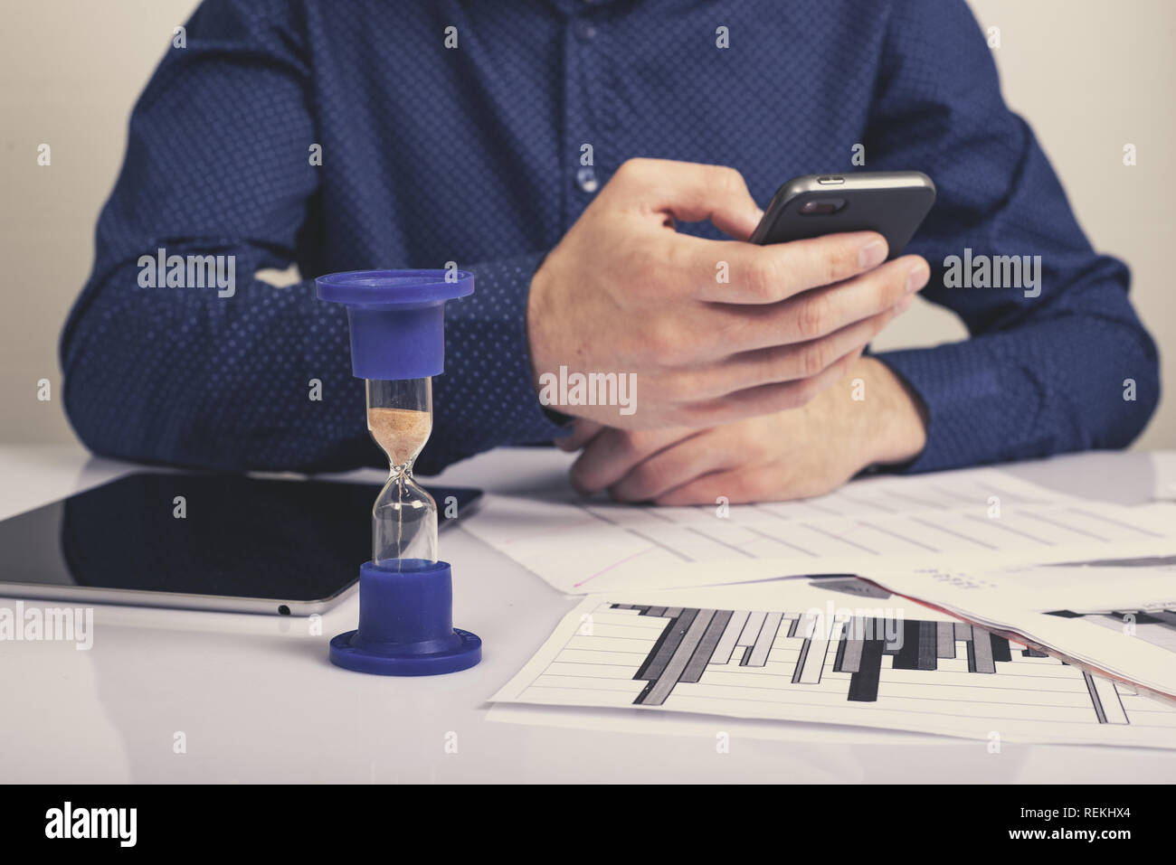 Sanduhr. Unternehmer im Büro im Hintergrund arbeiten. Konzept: Zeit ist Geld. Stockfoto